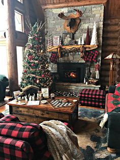 a living room decorated for christmas with a tree, couch and chess board on the coffee table