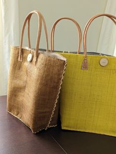 This is a super fun oversized bag that is made of woven raffia straw.  The bag has a great structured shape that will keep its form thanks to the double layer of straw. Made in Madagascar. Size: base of the bag - 11 x 5 inches, opening of the bag 22 inches. The height of the bag is 14 inches. Leather handles Cotton fabric with drawstring to keep things safe and secure Inner pocket Wooden button with a string loop for additional closure and design Large Capacity Natural Fiber Shopping Bag, Beach Shoulder Bag In Natural Burlap, Woven Burlap Tote Straw Bag, Natural Burlap Tote Straw Bag, Handwoven Burlap Straw Bag In Natural Color, Summer Burlap Tote Bag, Handwoven Burlap Bag In Natural Color, Daily Handwoven Burlap Straw Bag, Daily Use Handwoven Burlap Straw Bag