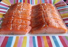 two pieces of salmon on a colorful plate