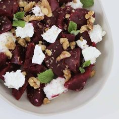 a white bowl filled with beets and feta cheese