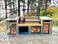 an outdoor grill made out of firewood in the woods