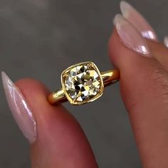 a close up of a person holding a ring with a diamond in it's center