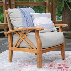 a wooden chair with pillows on top of it