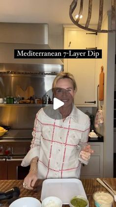 a man standing in front of a table with food on it and the words mediterranean 7 layer dip