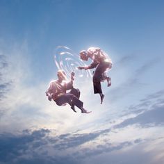 two people are flying through the air with their hands in each other's pockets