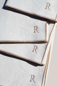 four folded napkins with the letters r and person written on them in cursive font