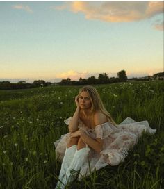 a woman sitting in the middle of a field