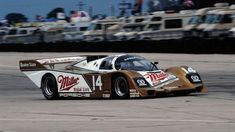 a race car driving around a track with other cars in the background