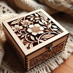 an intricate wooden box sitting on top of a blanket