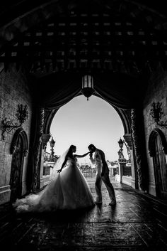 a bride and groom dancing in an archway