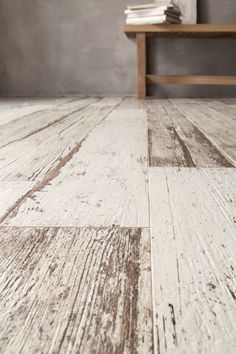 a wooden floor with white paint on it and a book shelf in the corner next to it