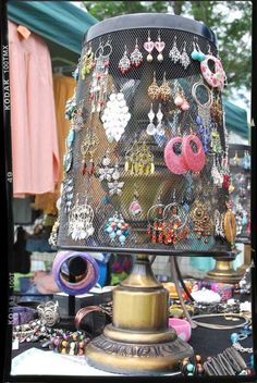 a lamp that is sitting on top of a table covered in earrings and earring hooks