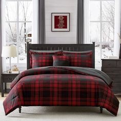 a red and black plaid comforter set in a room with two lamps on the side