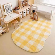 a child sits on the floor in front of a yellow and white checkered rug