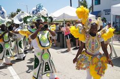 some people are walking down the street in colorful costumes