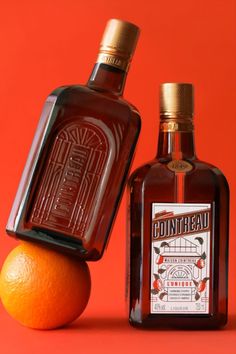 an orange next to two bottles of donuthead whiskey on a red background,