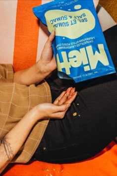 a person sitting on a couch holding up a book