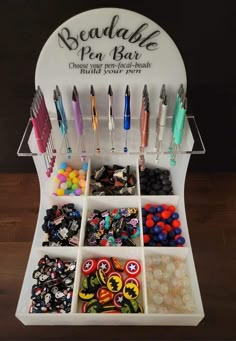 a display case filled with lots of different types of buttons and pens on top of a wooden table