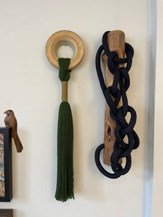 a wall mounted clock with a wooden handle and tassel hanging from it's side