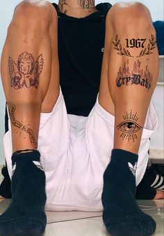 two men with tattoos on their legs sitting next to each other