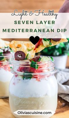 a spoon lifting up some food out of a jar with the words, light and healthy seven layer mediterranean dip