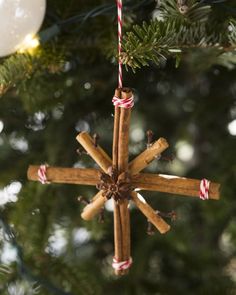 an ornament made out of cinnamon sticks and candy canes hanging from a christmas tree