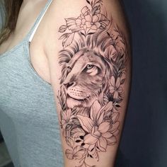 a woman's arm with a lion and flowers tattoo on the left side of her arm