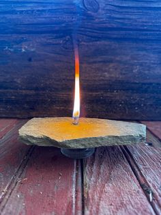 a lit candle sitting on top of a wooden table