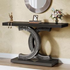 a black console table with a mirror on the wall