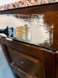 a close up of a paint brush on top of a cabinet