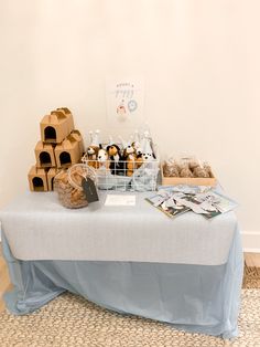 a table topped with lots of pastries on top of a blue cloth covered table