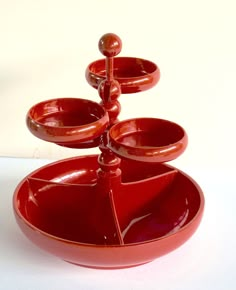 three red bowls stacked on top of each other in the shape of an upside down bowl