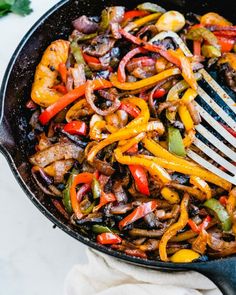 a skillet filled with stir fry vegetables and meat