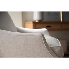 the back end of a chair with white linen