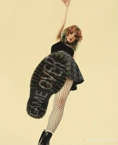 a woman is flying through the air with her leg in the air and wearing fishnet stockings