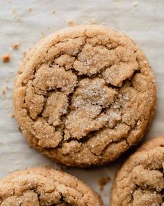 three sugary cookies are on a white surface