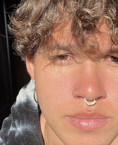 a close up of a person with a nose ring and piercing on it's nose