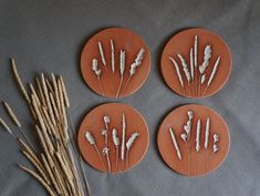 four orange plates with dried flowers on them