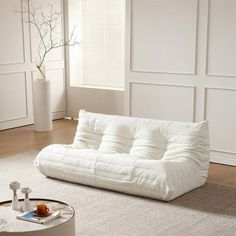 a white couch sitting on top of a rug in a living room