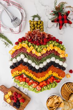 a platter filled with fruit and veggies on top of a white counter