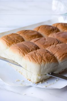 a piece of bread that is sitting on a white plate with a knife in it