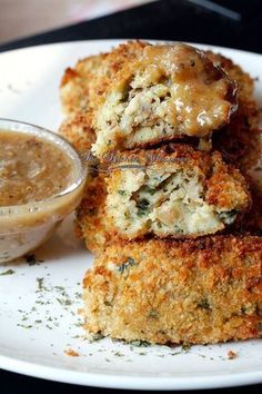 three crab cakes on a plate with dipping sauce