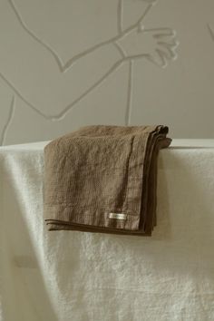 a towel hanging on the side of a bed