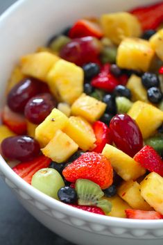 a white bowl filled with fruit salad on top of a table