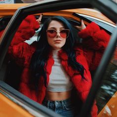 a woman wearing sunglasses sitting in the back seat of a car