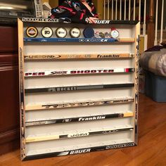 a display case with many different types of baseball bats on it and a man standing in the background