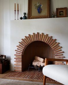 a living room with a fire place next to a chair and pictures on the wall