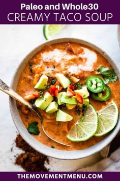 a bowl of creamy taco soup with limes, avocado and cilantro