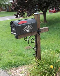 a mailbox with the name madison on it in front of a tree and grass