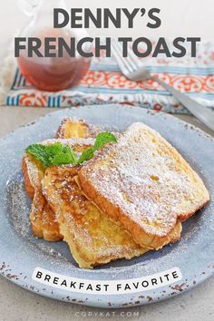 french toast with powdered sugar and mint on a plate next to a cup of tea